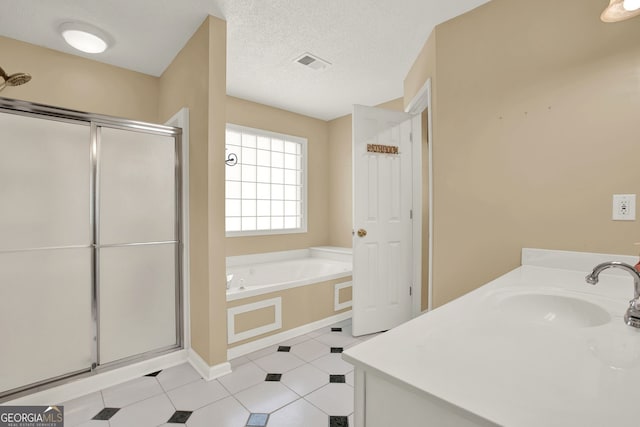 bathroom with vanity, a textured ceiling, and shower with separate bathtub