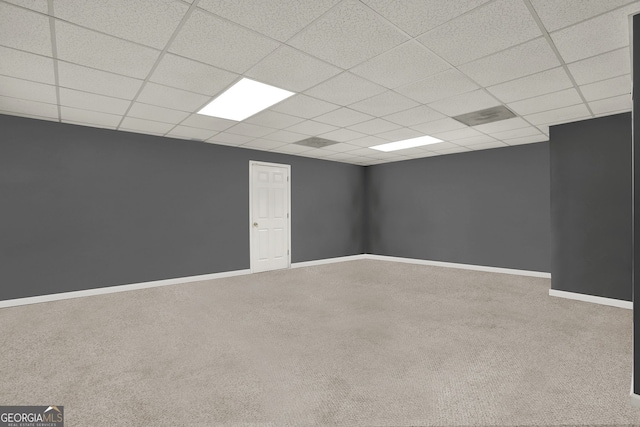 basement featuring carpet floors and a paneled ceiling