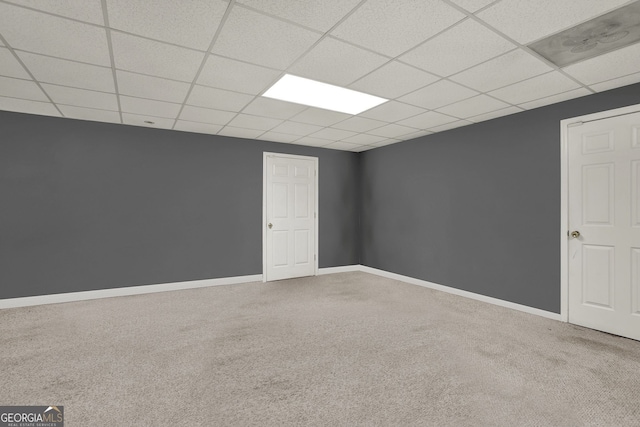 carpeted empty room featuring a paneled ceiling