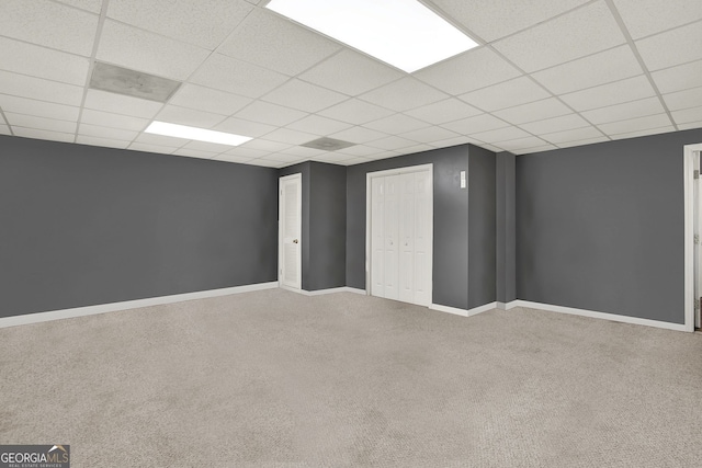 basement featuring a paneled ceiling and carpet