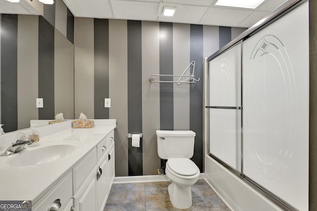 full bathroom with combined bath / shower with glass door, toilet, a paneled ceiling, vanity, and tile patterned flooring