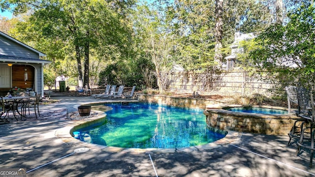 view of pool with a patio and an in ground hot tub