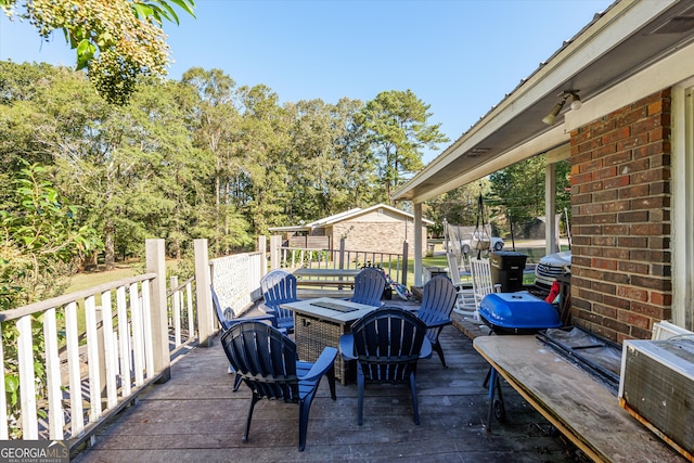 view of patio / terrace with an outdoor fire pit and a deck