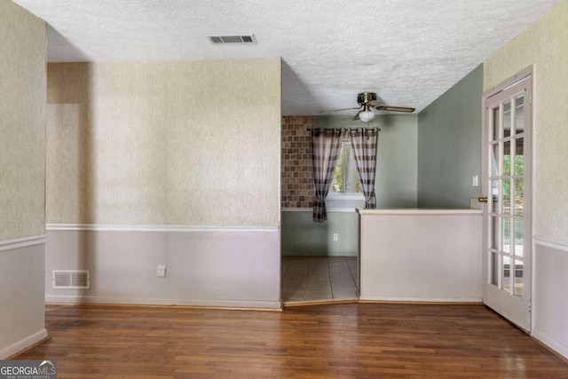 unfurnished room with hardwood / wood-style floors, a textured ceiling, and ceiling fan