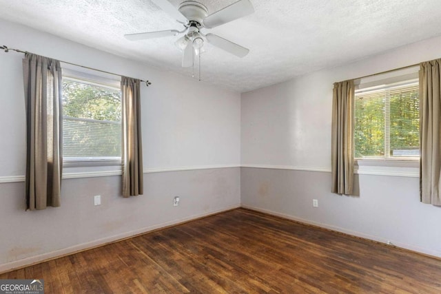 unfurnished room featuring dark wood-type flooring, a textured ceiling, and plenty of natural light