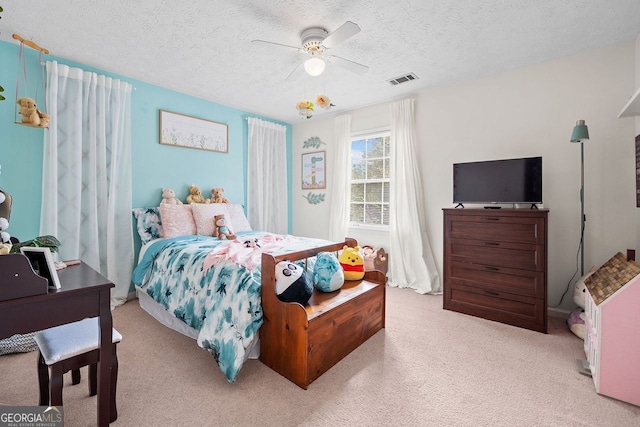 carpeted bedroom featuring ceiling fan and a textured ceiling