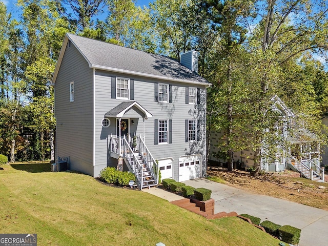 view of front of home featuring a front yard, central AC unit, and a garage