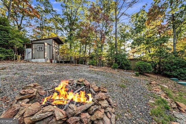 view of yard with an outdoor fire pit and an outbuilding