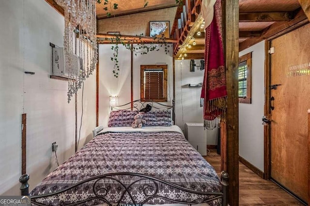 bedroom featuring beamed ceiling and hardwood / wood-style floors