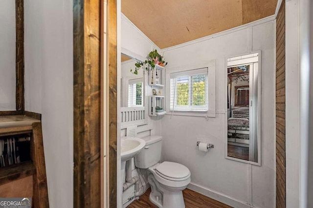 bathroom featuring ornamental molding, lofted ceiling, hardwood / wood-style flooring, and toilet