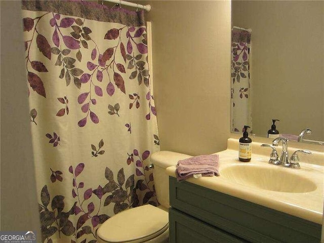 bathroom featuring vanity, toilet, and a shower with curtain