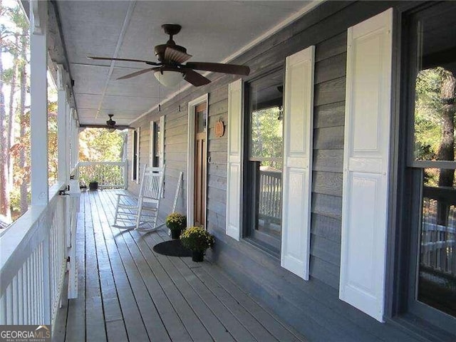 wooden terrace with a porch and ceiling fan