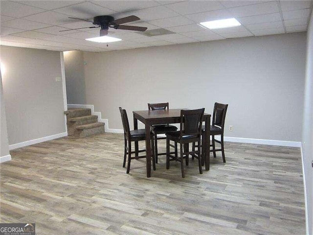 dining space featuring ceiling fan, hardwood / wood-style flooring, and a paneled ceiling