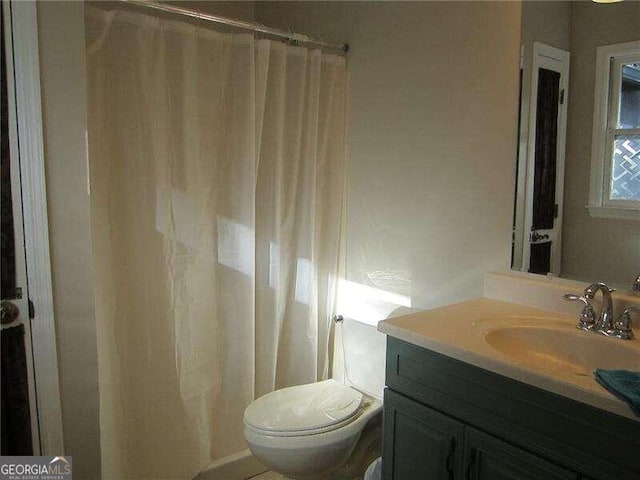 bathroom featuring vanity, toilet, and walk in shower