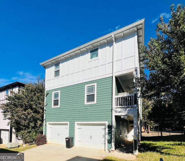 view of side of home featuring a garage and a balcony