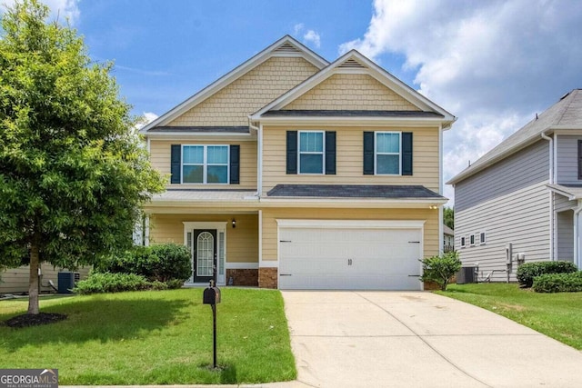 craftsman-style house featuring a front yard, central AC unit, and a garage