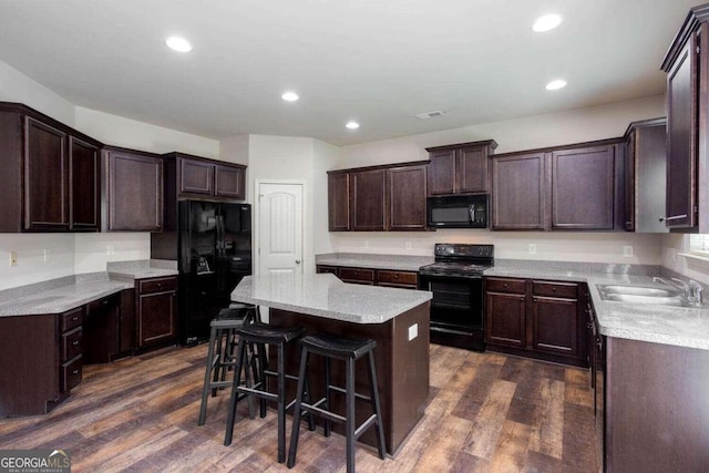 kitchen with sink, black appliances, a center island, and dark hardwood / wood-style floors