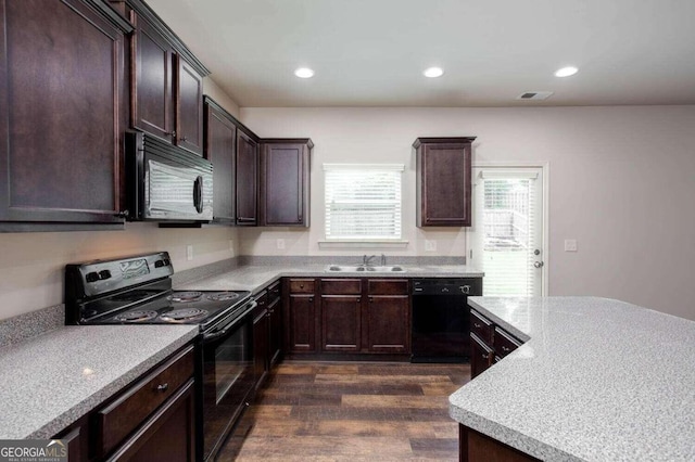 kitchen featuring dark brown cabinets, black appliances, sink, and dark hardwood / wood-style floors