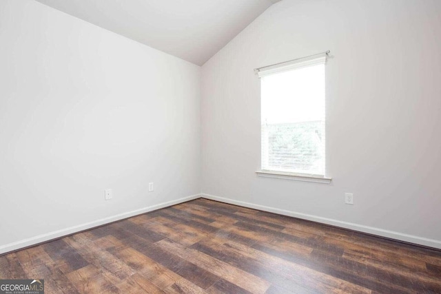 spare room with lofted ceiling and dark hardwood / wood-style flooring