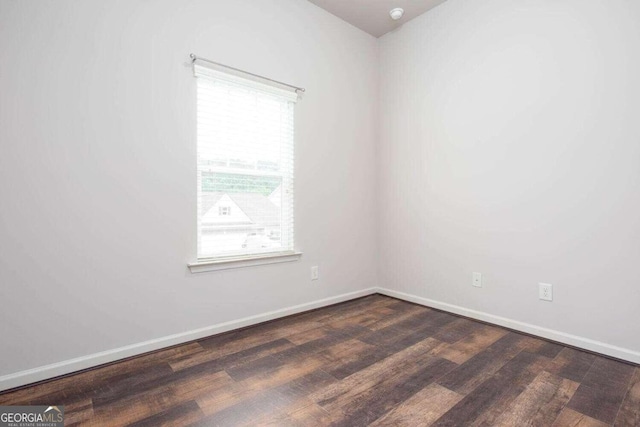 empty room with plenty of natural light and dark hardwood / wood-style flooring