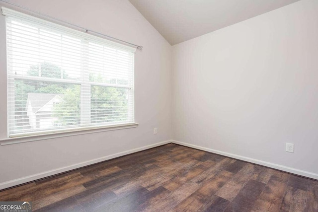 unfurnished room featuring lofted ceiling, dark hardwood / wood-style floors, and plenty of natural light