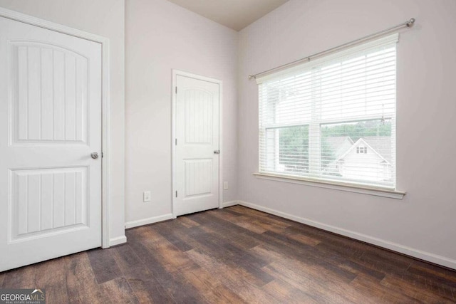 unfurnished bedroom with dark wood-type flooring