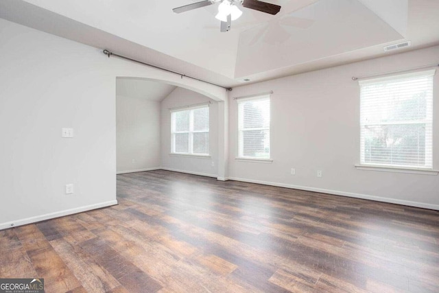 empty room with lofted ceiling, dark wood-type flooring, and ceiling fan