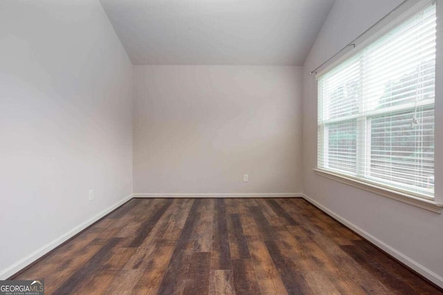 unfurnished room with dark hardwood / wood-style floors and vaulted ceiling