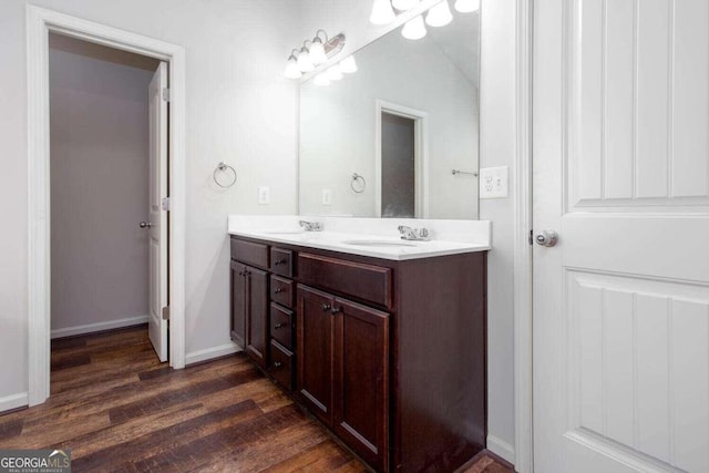 bathroom featuring vanity, vaulted ceiling, and wood-type flooring