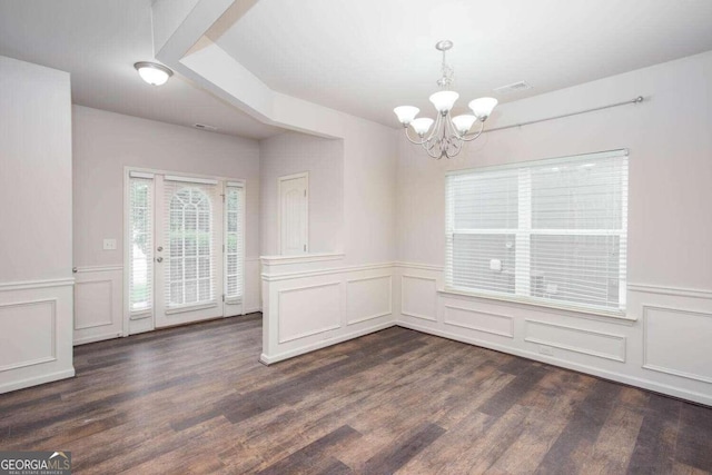 unfurnished dining area featuring a notable chandelier and dark hardwood / wood-style floors