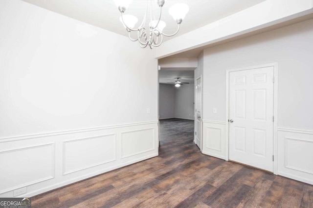 unfurnished dining area with dark hardwood / wood-style floors and ceiling fan with notable chandelier