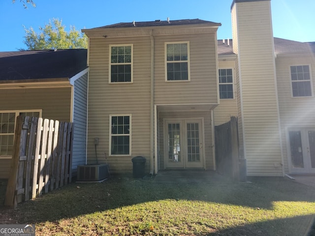 back of property featuring french doors, a yard, and central air condition unit