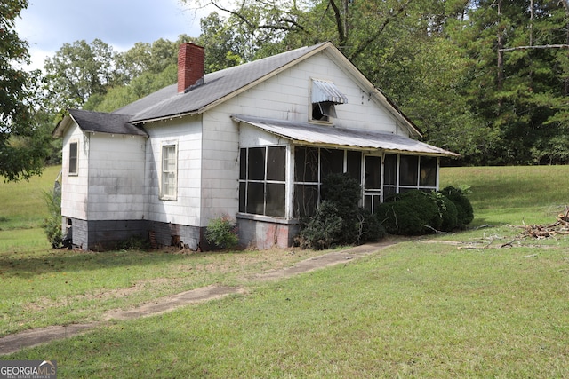 view of front of home with a front yard and a sunroom