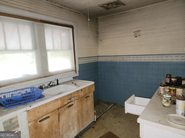 bathroom with vanity and tile walls