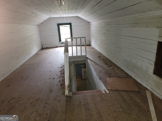 additional living space with wooden ceiling, wood-type flooring, vaulted ceiling, and wooden walls