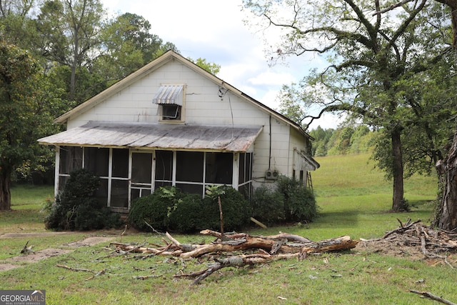 view of front of property featuring a front lawn and a sunroom