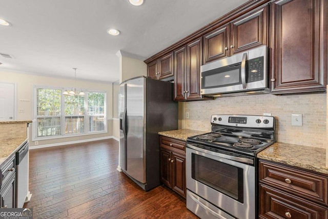 kitchen with dark wood-type flooring, crown molding, decorative light fixtures, appliances with stainless steel finishes, and tasteful backsplash