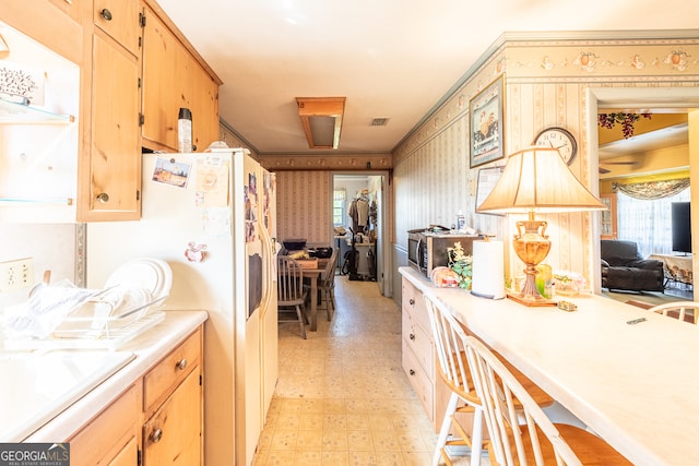 kitchen featuring light brown cabinetry, sink, and white fridge with ice dispenser