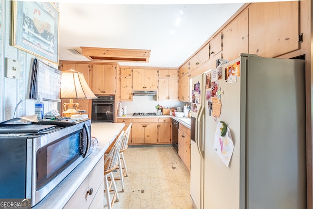 kitchen featuring light brown cabinets and black appliances