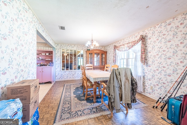 dining room with parquet floors, a chandelier, and a textured ceiling