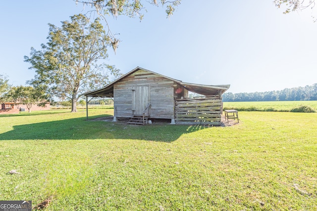 view of outdoor structure with a lawn and a rural view