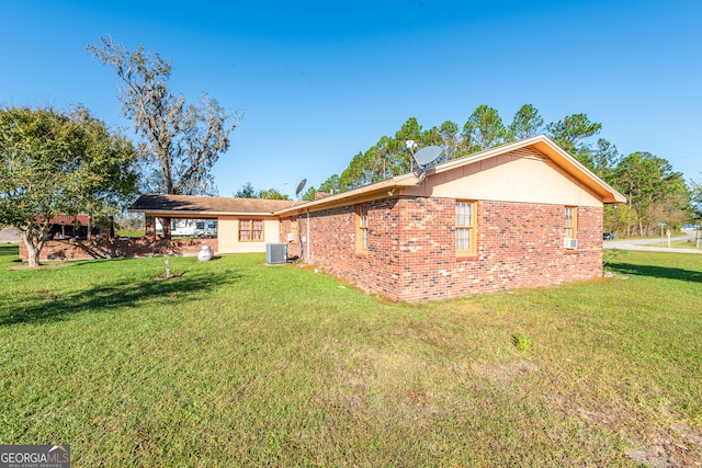 back of house with cooling unit and a lawn