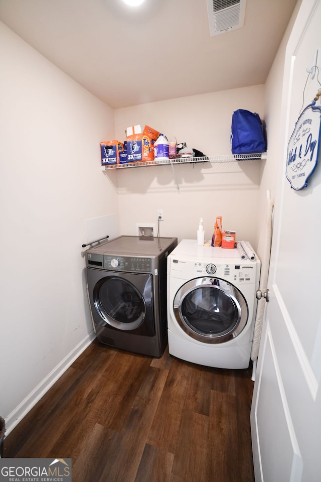 clothes washing area with dark hardwood / wood-style flooring and washing machine and clothes dryer