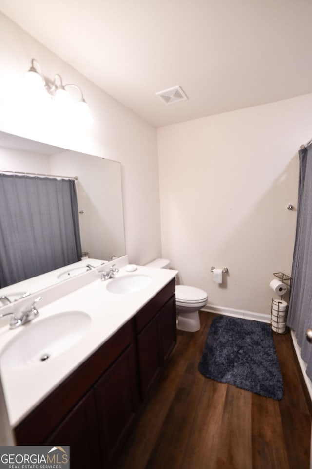 bathroom with vanity, toilet, and wood-type flooring