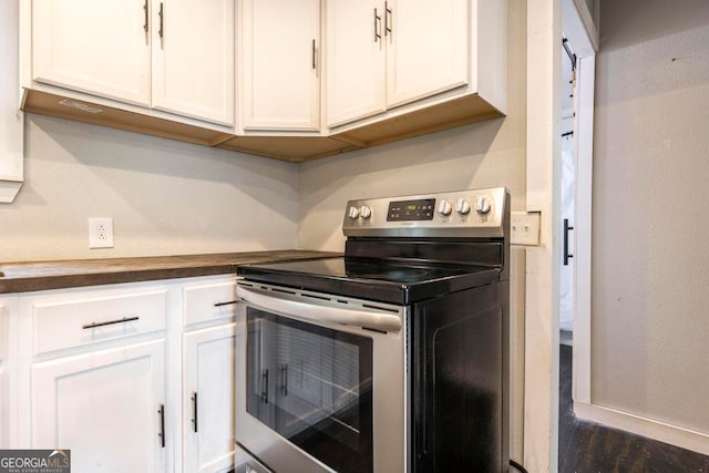 kitchen with white cabinets, stainless steel range with electric cooktop, and dark hardwood / wood-style flooring