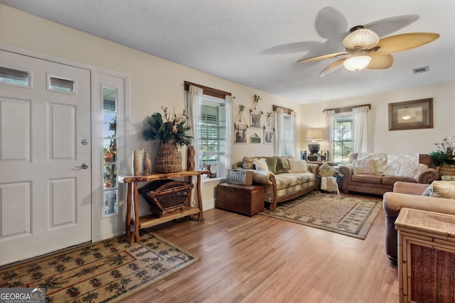 living room featuring a textured ceiling and light hardwood / wood-style flooring