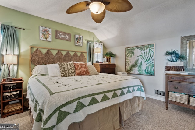 carpeted bedroom featuring multiple windows, a textured ceiling, vaulted ceiling, and ceiling fan