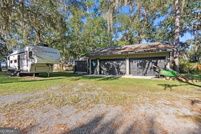 view of yard featuring a garage and an outbuilding