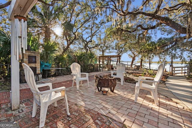 view of patio / terrace featuring a water view and a fire pit