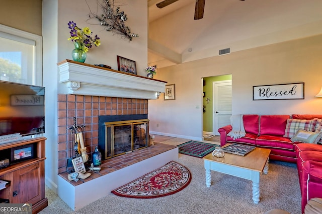 carpeted living room with a tiled fireplace, high vaulted ceiling, and ceiling fan